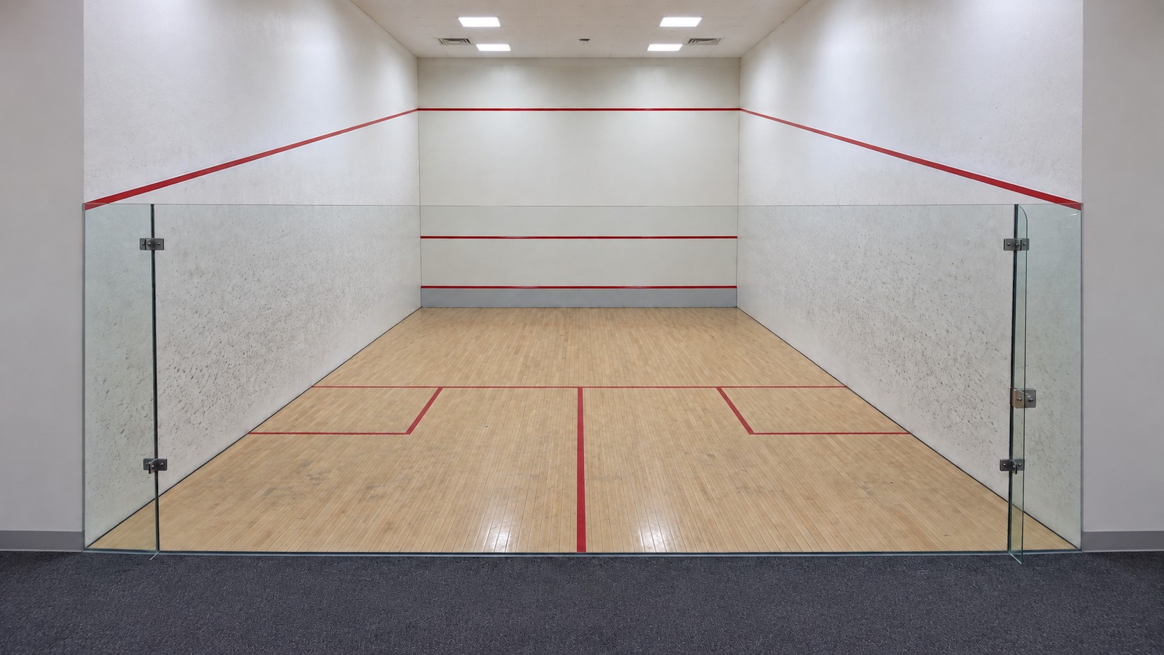 Landscape squash court view showing the upper red boundary across both side walls and the front wall, the front service line, and the lower tin line.